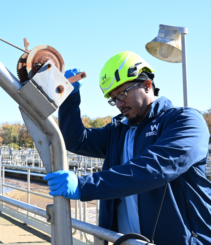Wastewater Operator lowering a bucket to test wastewater