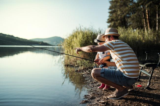Dad and son fishing on river