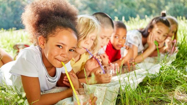 Children drinking clean water outside on a sunny day