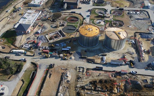Center of the photo, to the left of the Digesters, is the Cake Receiving Facility.  The vault portion of this building is completed and has been backfilled.