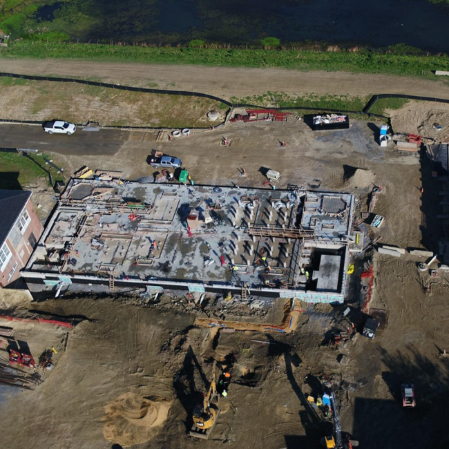 In the center of the photo is the Solids Building.  On the right side of the building you can see some of the piers that have been constructed that will support the belt filter presses which are key to the dewatering process.  On the right side of the photo is the Final Cake Storage Building.  The slab is complete and some of the walls are in place.