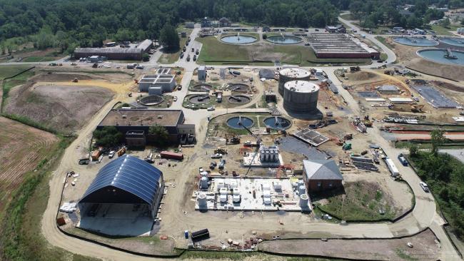 Aerial photo taken August 2, 2021.  The Cake Storage Facility with it’s signature blue canopy is at the lower left.  The slab for the Solids Building is to the right of that with the chemical storage tanks and the new belt filter presses still under wrap.  Above the Solids Building is our new Cambi Thermal Hydrolysis Process equipment (steel vertical tanks) which was delivered to the site last week.  This equipment is key to this entire project and will allow us to produce the Class A biosolids.