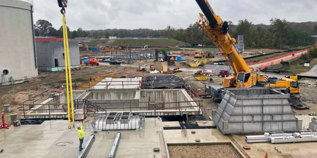 That pyramid-looking structure on the right is the receiving hopper (it’s upside down) that will be installed over that concrete box in the middle of the pit on the left.  Everything will be dumped into the hopper then transferred to the silos.