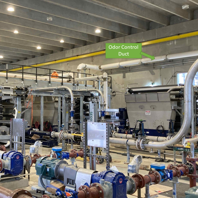 View inside the Solids Building which houses the Belt Filter Presses used for dewatering the biosolids.  The white duct work running along the top of the wall is for the Odor Control system.