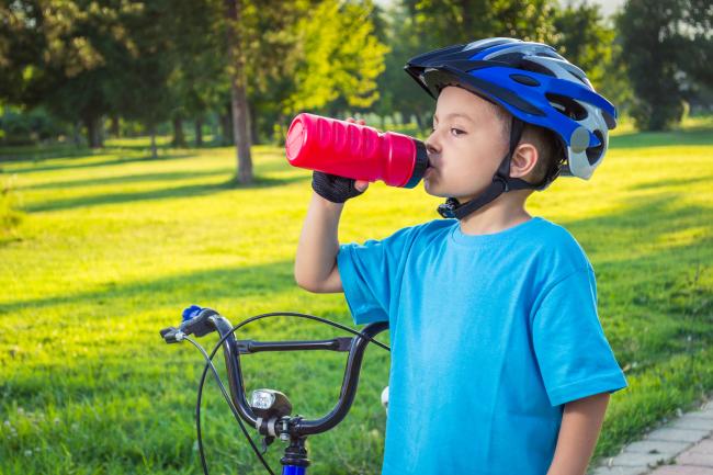 summer boy bike helmet drinking water