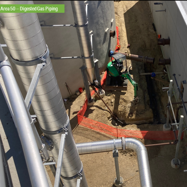 This photo is taken from the top of the Digester looking down between the Digester and the Digester Control Building.  It shows the pipe connections between the two.