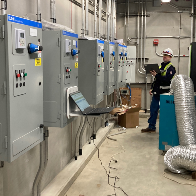 Electrical contractor inspecting the motor control cabinets preparing for the start-up inside the Solids Building Electrical Room