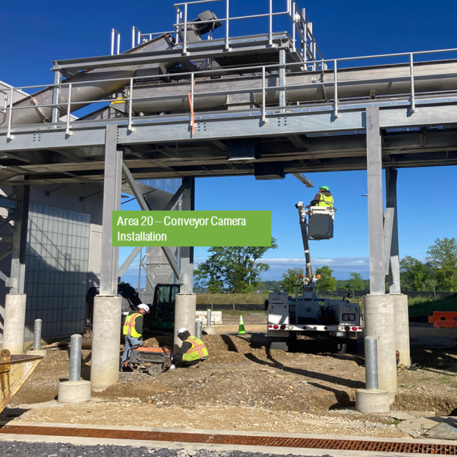 Workers are installing the monitoring camera on the conveyor system between the Solids Building and the Biosolids Storage Facility.