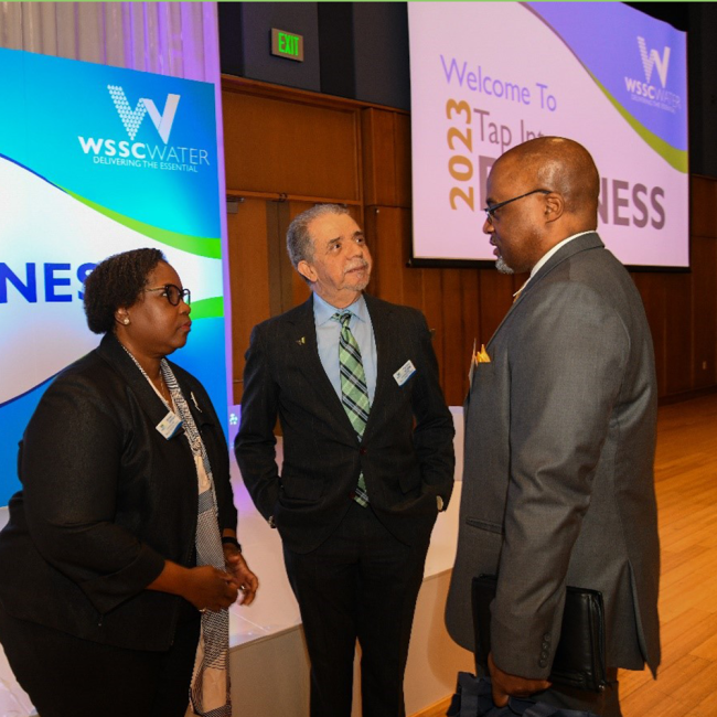 Commission Vice Chair Regina Speed-Bost (left) and Commission Chair Fausto Bayonet (middle) speaking with an attendee.
