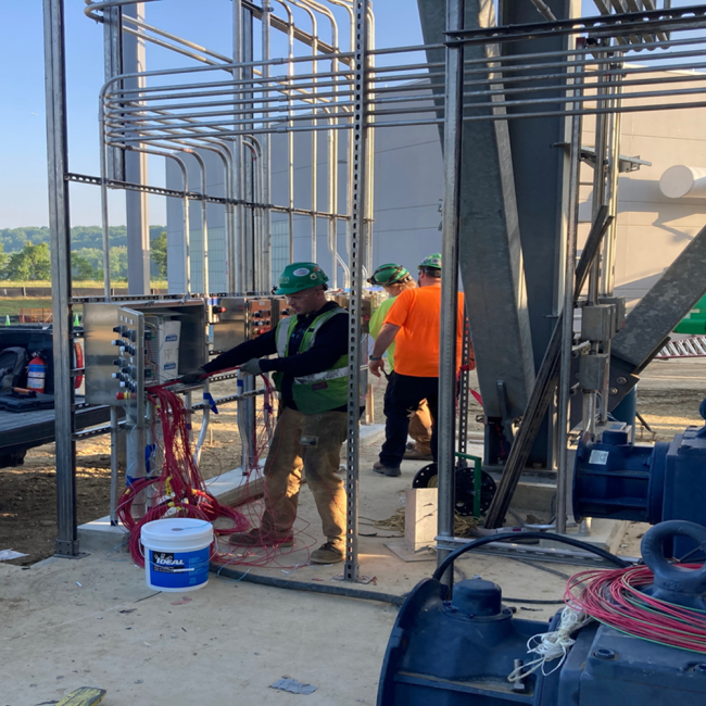 Electricians pulling the control wiring at the Cake Receiving Facility.