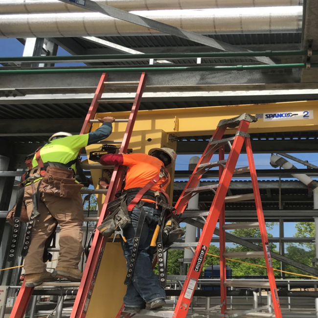 Workers installing the jib crane at the Cake Receiving Facility.  