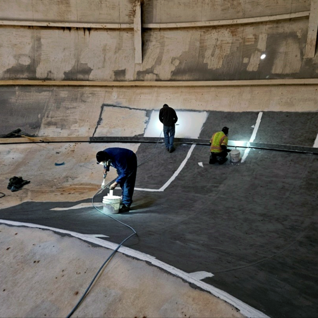 Applying the prime coat of the new coating system to the prepared steel in the interior of the tank.