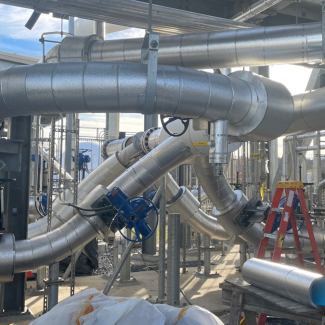 Workers on break.  They are adding the insulation to the piping at the Cake Receiving Facility.