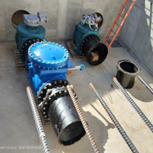 Setting up piping and valves in the Altitude Valve Vault. The image shows a check valve and two (2) plug valves installed in the openings from image one (1).