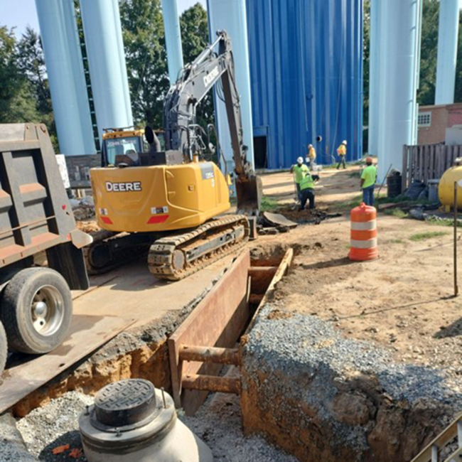 Manhole and Drainage System This picture shows the manhole and pipes used to move water away from the site. The overflow drain is designed to empty the tank if it fills up too much.