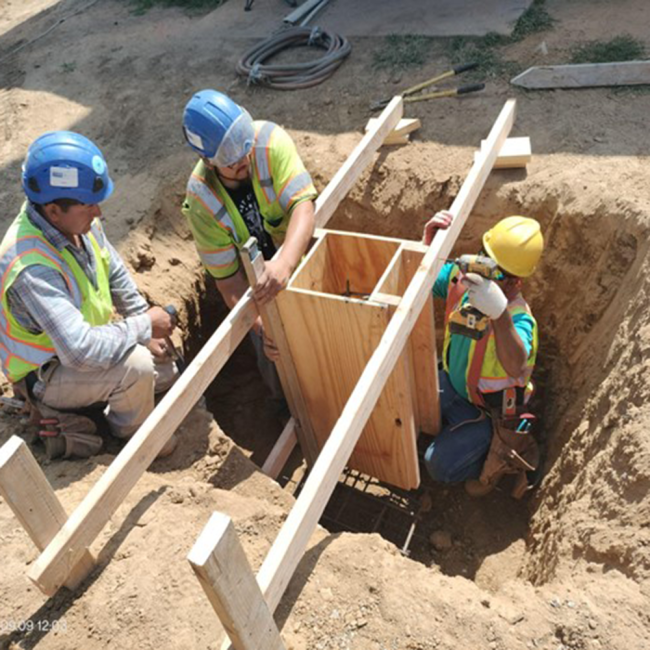 Concrete Pipe Support The crew is building a concrete base to support the overflow pipe. This base keeps the pipe stable, in place, and able to handle different pressures.
