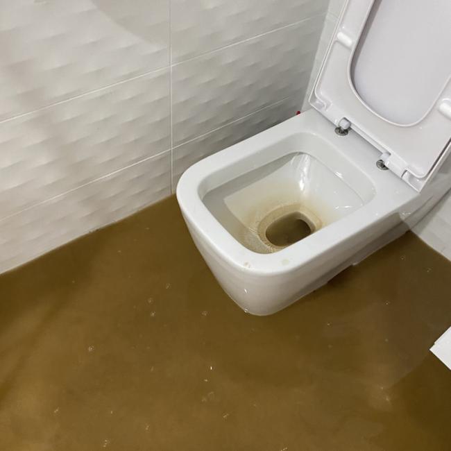 Sewage on the floor of a bathroom where the toilet overflowed from a backup.